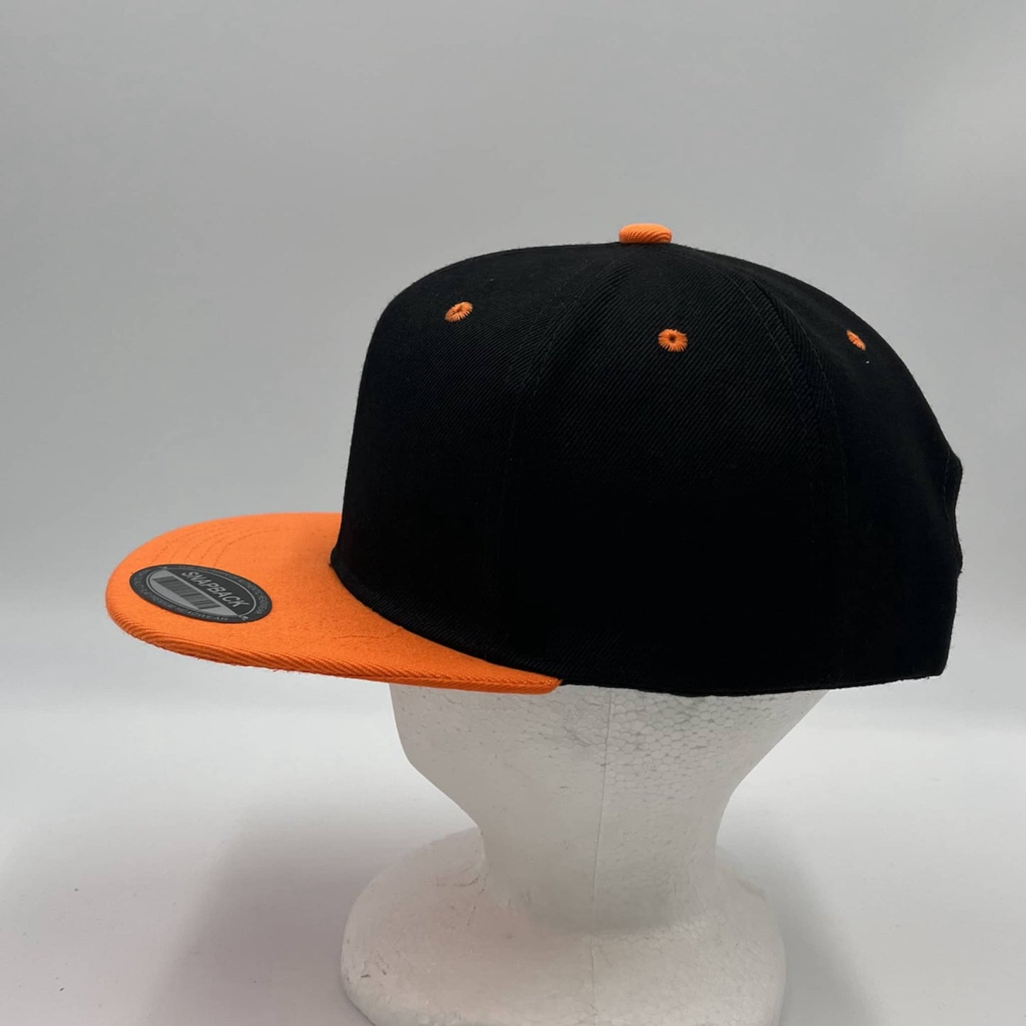 Alpha Omega Cap Plain Poly Snapback Black and Orange Eyelets/Bill 12 pack PFS0552 Cap Hat